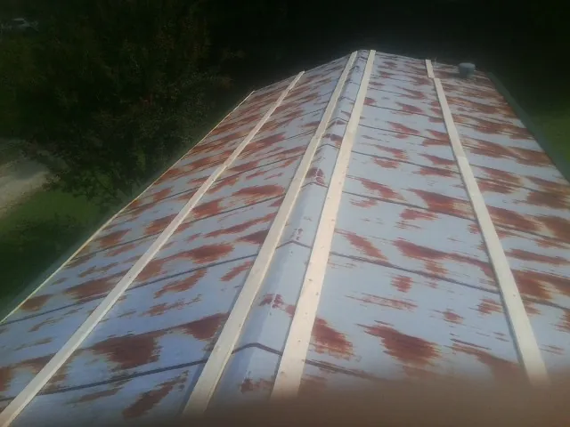 Rusted metal roof panels with new wood purlins before replacement — Storm Damage Roof Repair in Alstead by Roofing Brothers