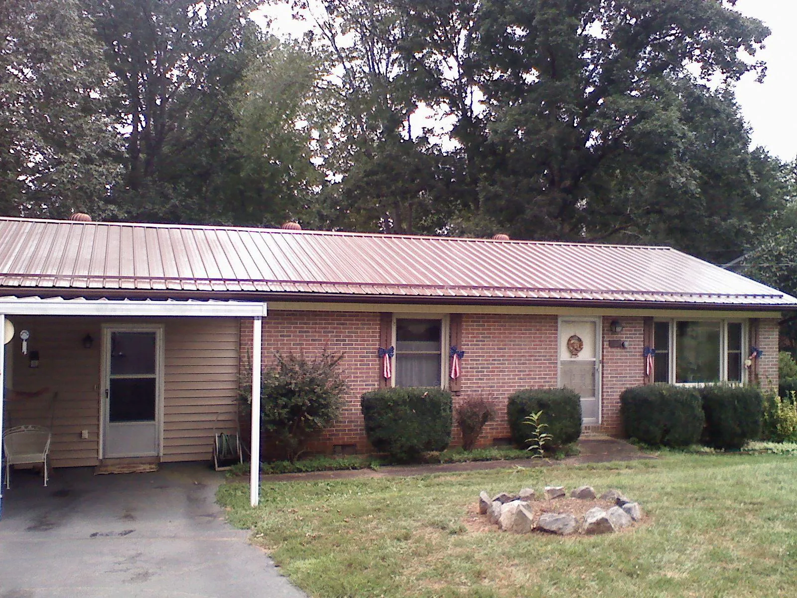 Bronze metal roof and carport on a brick ranch home — Roof Repair work by our crew in Alstead